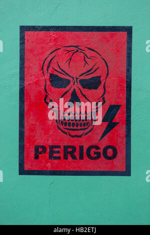 MANAUS, BRAZIL, MARCH 25: Red graffiti of skull with the word danger on vintage green wall (Perogo in Portuguese). Manaus. Brazil 2015 Stock Photo