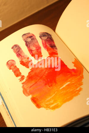 Photograph of a human hand shape painted on a notebook Stock Photo