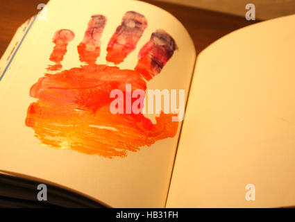 Photograph of a human hand shape painted on a notebook Stock Photo