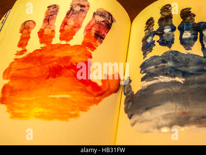 Photograph of a pair of human hands shapes painted on a notebook Stock Photo