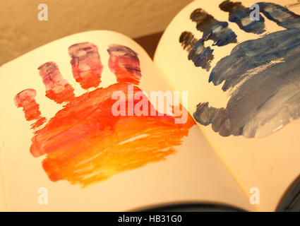 Photograph of a pair of human hands shapes painted on a notebook Stock Photo