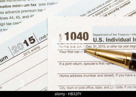 Gold pen laying on 2015 IRS form 1040 Stock Photo