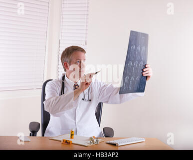 Doctor pointing pen at x-ray chart Stock Photo