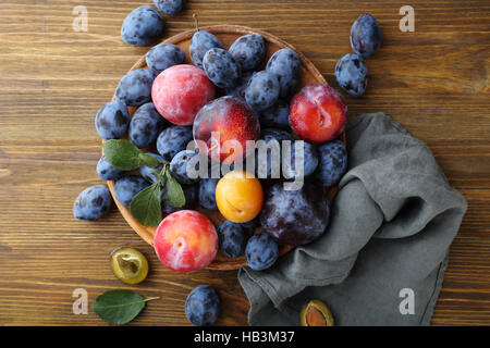 Ripe plums on rustic background, food above Stock Photo