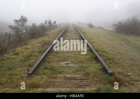 Old railway line shrouded in the fog. Stock Photo