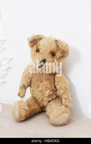 Retro Teddy Bear toy alone on wooden cupboard Stock Photo