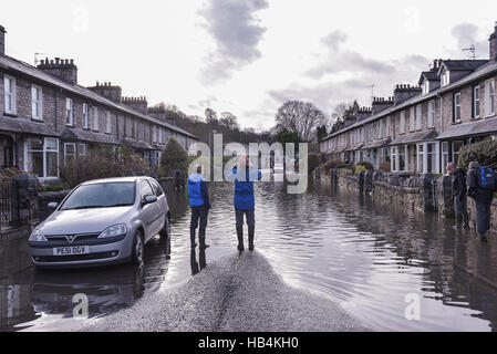 A man takes a picture of a flooded street in Kendal, Cumbria on the 6th of December 2015. Stock Photo