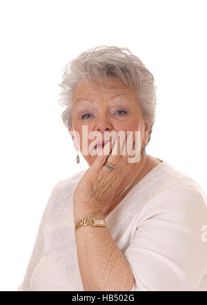 Senior woman holding face in her hand. Stock Photo