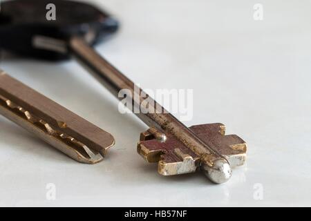 Silver key against white background close-up. Stock Photo