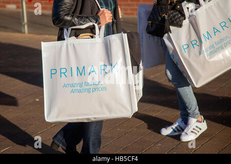 Shoppers with Primark large reusable bags of festive store purchases at Houndshill Shopping Centre, Bank Hey St, Blackpool Lancashire, UK Stock Photo