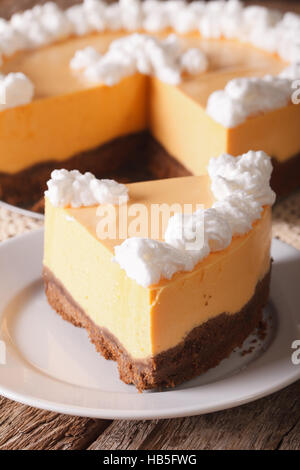 slice of pumpkin cheesecake close-up on a plate on the table. vertical Stock Photo