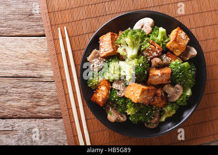 Savory sauteed mixed chinese vegetables with crispy fried tofu on a plate. Horizontal view from above Stock Photo