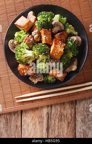 Savory sauteed mixed chinese vegetables with crispy fried tofu on a plate. vertical view from above Stock Photo