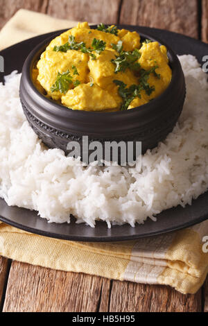 Indian chicken Korma with basmati rice close-up on the table. Vertical Stock Photo