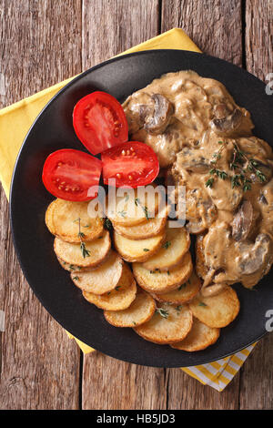 Diana steak with mushrooms and cream sauce close-up on a plate. Vertical view from above Stock Photo