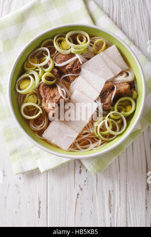 Korean cuisine: Galbitang soup with beef ribs, rice noodles and daikon close up in a bowl. vertical view from above Stock Photo