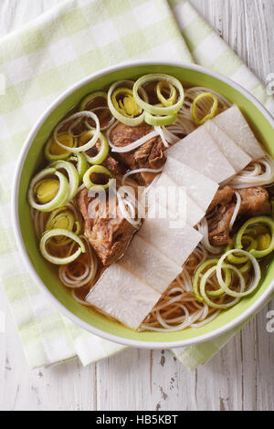 Galbitang Korean soup with beef ribs, rice noodles and daikon close up in a bowl. vertical view from above Stock Photo