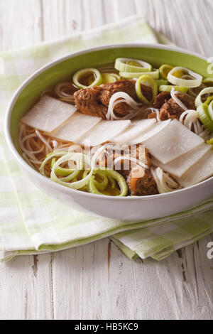 Korean beef ribs soup, rice noodles, leeks and daikon close up in a bowl. Vertical Stock Photo