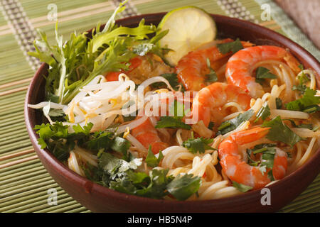 Malaysian laksa soup with prawns close up in a bowl on the table. horizontal Stock Photo