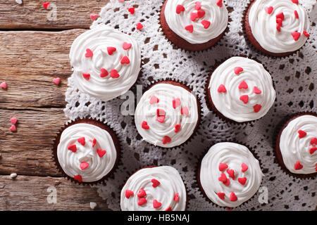 red velvet cupcakes decorated with hearts close-up on the table. horizontal view from above Stock Photo