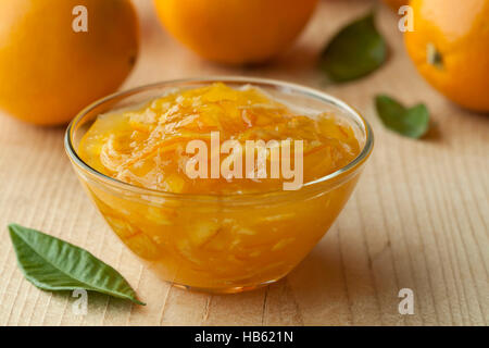 Bowl with homemade orange marmalade and fresh oranges in the background Stock Photo