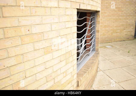 Silver metal bars covering a hole in the wall leading to underground car park Stock Photo