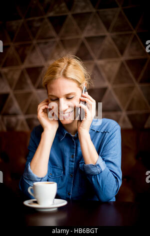 Young woman sitting in cafe , using telephone and drinking coffe Stock Photo