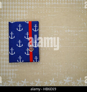 Small notebook with ancor design lying on paper Stock Photo