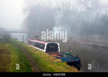 Narrow boat, in fog, on the Trent and Mersey Canal near Sandbach Cheshire UK Stock Photo