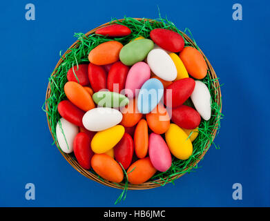 Easter basket filled with colorful and sweet eggs Stock Photo