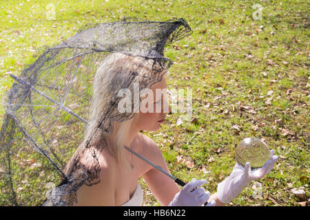 Woman with lace umbrella and glass ball Stock Photo