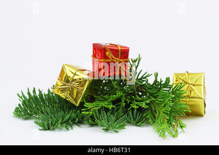Three golden, red shiny Christmas presents on fresh pine with copy space Stock Photo