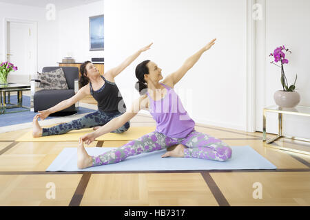 Two women doing yoga at home Stock Photo