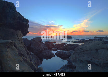 Long exposure of sunset over rocks Stock Photo