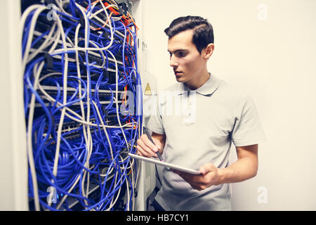 System administrator with digital tablet in a server room Stock Photo