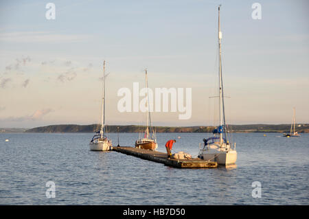 Yachtsman inflating his dinghy at Dale outer pontoon before going ashore Stock Photo