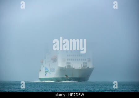 The Isle of Inishmore Irish ferry appears out of the sea mist entering Milford Haven on a misty summers day. Stock Photo