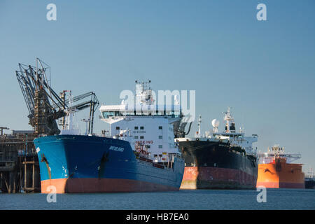 Three tankers at Valero oil terminal in Milford Haven on a calm November day with clear blue sky Stock Photo