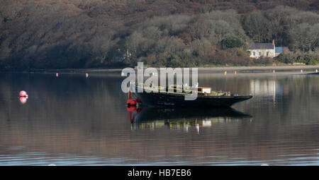 Old sailing boat at a buoy on the Upper Cleddau at Lawrenny on a calm November day reflection in the calm waters Stock Photo