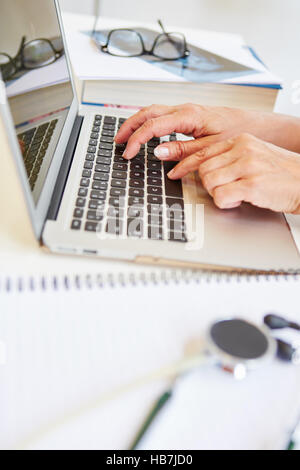 Laptop at office of doctor while writing and typing distance study paper Stock Photo