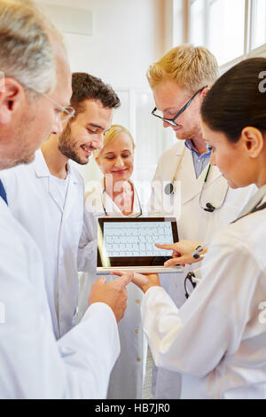 Team of doctors analyzing ECG on tablet computer Stock Photo