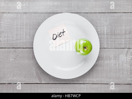 Healthy diet with fresh organic apple on the plate on wooden board Stock Photo