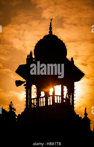 Shveta Varahaswamy Temple, Mysore Palace, Mysore or Mysuru, Kernataka, India, at sunset with a tower silhouetted in sky. Stock Photo