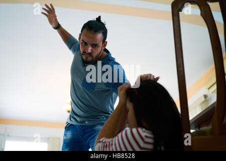 Social issues, abuse and aggression on women, young drunk man hitting and beating woman at home after drinking alcohol. Violent husband fighting with Stock Photo