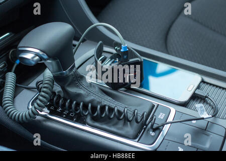 Modern car interior with smart watch and smart phone on gear stick. Stock Photo