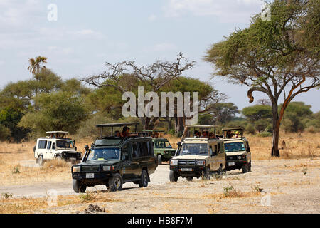 Tourists on safari, ATVs driving through bush, Ngorongoro, Serengeti National Park, Tanzania Stock Photo