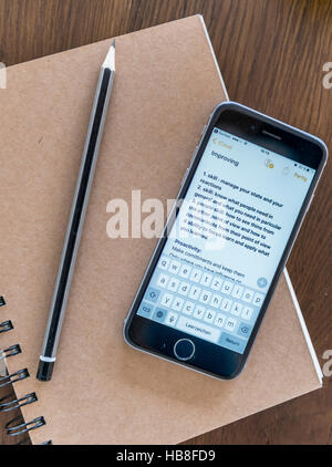 Notes on smartphone, notebook and pen on a wooden table Stock Photo