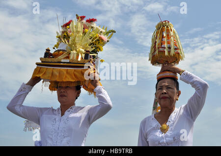 Bali, Indonesia - March 20, 2015 : Balinese woman in traditional clothes carrying ceremonial offerings on her head during Nyepi Day in Bali - Indonesi Stock Photo