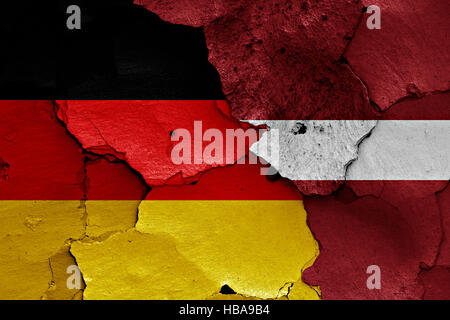 flags of Germany and Latvia painted on cracked wall Stock Photo