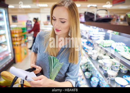 WOman reading shopping list in store Stock Photo